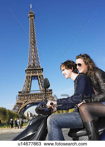 Stock Image - Couple on moped in Paris. Fotosearch