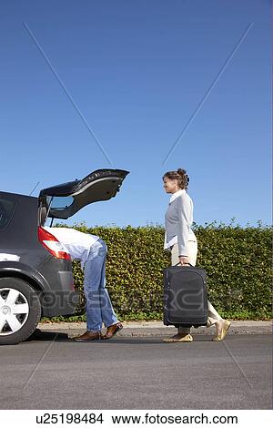 Couple putting bags into car View Large Photo Image Picture - Couple putting bags into car. Fotosearch