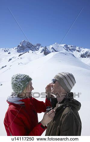 Stock Image - Couple putting on suntan lotion. Fotosearch