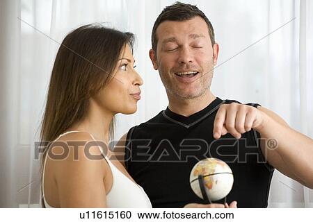Stock Image - Couple searching World for vacation. Fotosearch
