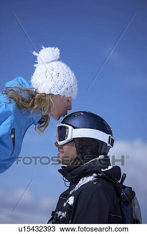 Stock Image - Couple sitting close in chair lift. Fotosearch