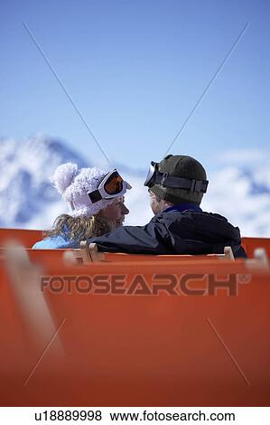 Couple sitting close in chair lift View Large Photo Image Stock Photo - Couple sitting close in chair lift. Fotosearch