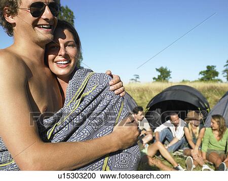 Couple wrapped in a cover at a festival View Large Photo Image Stock Image - Couple wrapped in a cover at a festival. Fotosearch