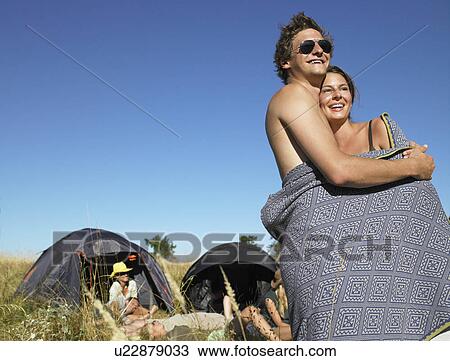 Couple wrapped in a cover at a festival View Large Photo Image Stock Image - Couple wrapped in a cover at a festival. Fotosearch