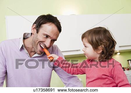 Stock Image - Dad and child cooking together. Fotosearch