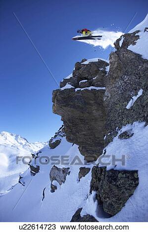 Stock Image - Extreme skier jumping from rock. Fotosearch