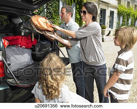 Stock Photograph - Family charging bags in the trunk. Fotosearch