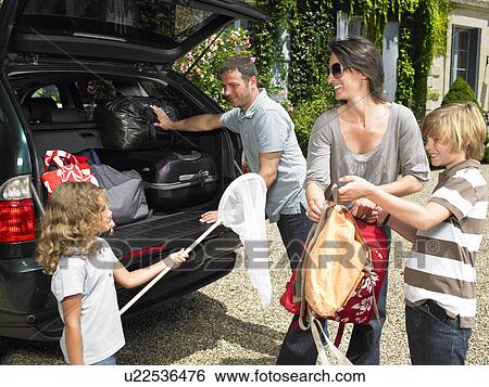 Stock Photograph - Family charging bags in the trunk. Fotosearch