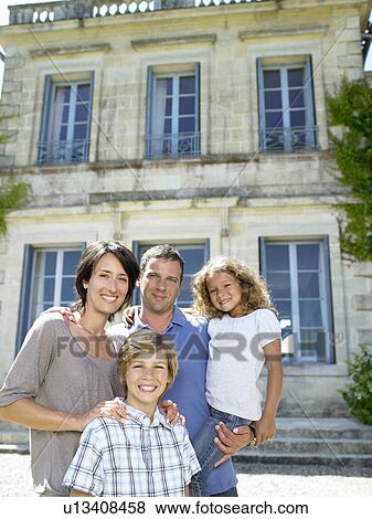 Family standing in front of a house View Large Photo Image Stock Photo - Family standing in front of a house. Fotosearch