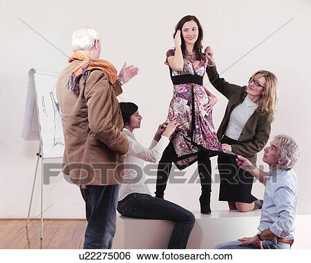 Stock Photograph - Fashion designers adjusting dress. Fotosearch