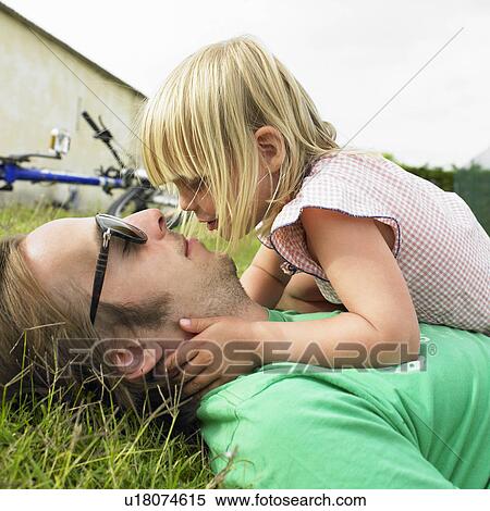 Father and daughter laying on grass View Large Photo Image Stock Photography - Father and daughter laying on grass. Fotosearch