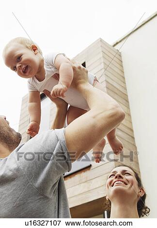 Stock Photo - Father holding baby in the air. Fotosearch