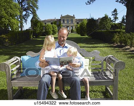 Father reading a book to his kids View Large Photo Image Stock Image - Father reading a book to his kids. Fotosearch