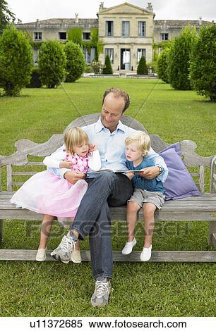 Father reading a book to his kids View Large Photo Image Stock Photography - Father reading a book to his kids. Fotosearch