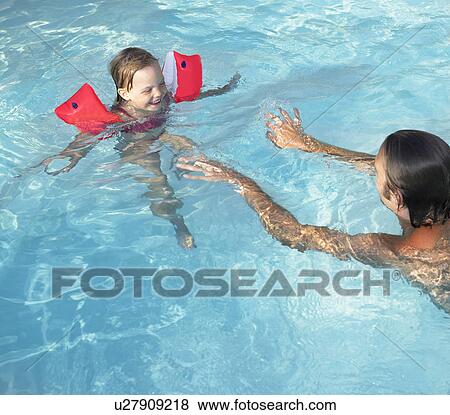 Father teaching daughter how to swim View Large Photo Image Stock Photo - Father teaching daughter how to swim. Fotosearch