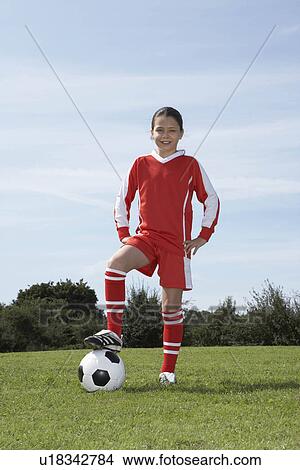 Picture - Female footballer standing with ball. Fotosearch