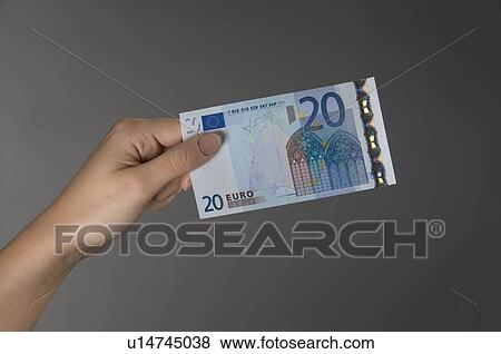 Stock Photo - Female hand holding a Euro banknote. Fotosearch