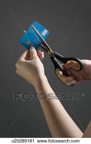 Stock Image - Female hands cutting credit card. Fotosearch