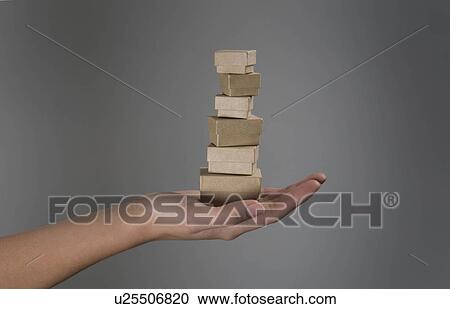 Stock Image - Female hands holding pile of small boxes. Fotosearch