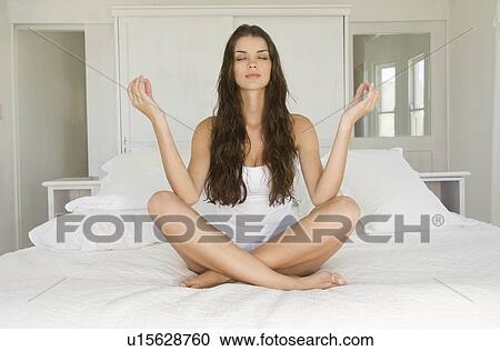 Female in yoga pose sitting on bed View Large Photo Image Stock Image - Female in yoga pose sitting on bed. Fotosearch