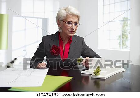 Stock Image - Female senior architect at work in loft. Fotosearch