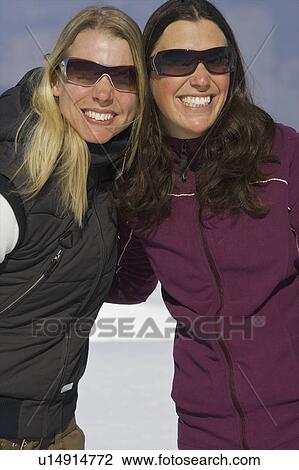Stock Image - Female snowboarder hugging. Fotosearch