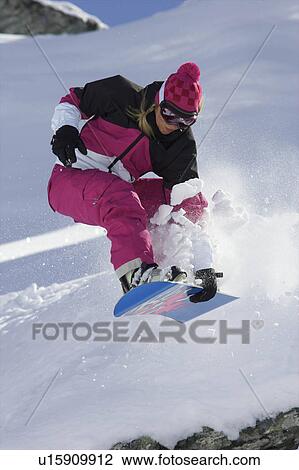 Female snowboarder jumping with a grab View Large Photo Image Stock Image - Female snowboarder jumping with a grab. Fotosearch