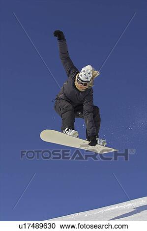 Female snowboarder jumping with a grab View Large Photo Image Stock Image - Female snowboarder jumping with a grab. Fotosearch