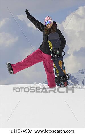 Stock Photo - Female snowboarder playing around in the. Fotosearch