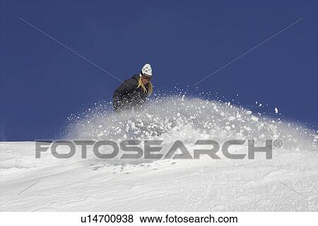 Stock Photo - Female snowboarder turning in the snow. Fotosearch