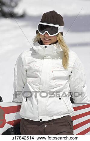 Picture - Female snowboarder walking with her snow. Fotosearch
