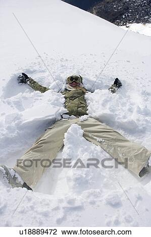 Stock Image - Female snowboarder walking with her snow. Fotosearch