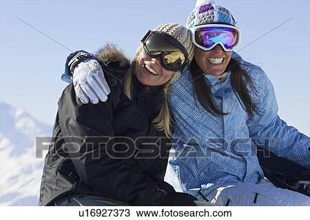 Stock Image - Female snowboarders smiling. Fotosearch