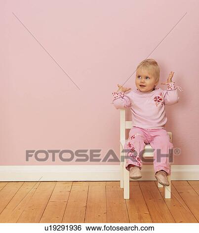 Female toddler sitting on chair View Large Photo Image Stock Photograph - Female toddler sitting on chair. Fotosearch