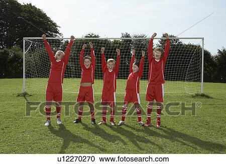 Stock Image - Football Team cheering in front of goal. Fotosearch