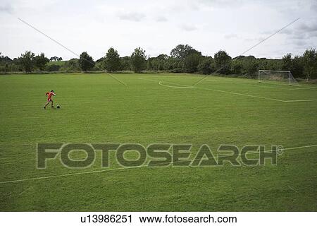 Footballer dribbling a ball towards goal View Large Photo Image Stock Image - Footballer dribbling a ball towards goal. Fotosearch