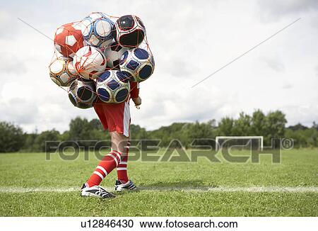Footballer struggles with bag of balls View Large Photo Image Stock Image - Footballer struggles with bag of balls. Fotosearch