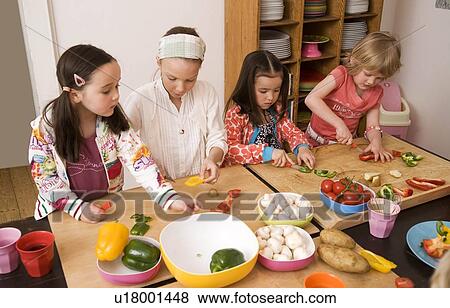 Four girls cutting vegetables View Large Photo Image Stock Photo - Four girls cutting vegetables. Fotosearch