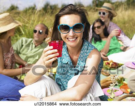 Friends having a picnic in a field View Large Photo Image Picture - Friends having a picnic in a field. Fotosearch