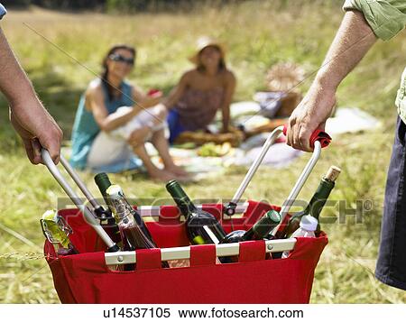 Friends having a picnic in a field View Large Photo Image Stock Photography - Friends having a picnic in a field. Fotosearch