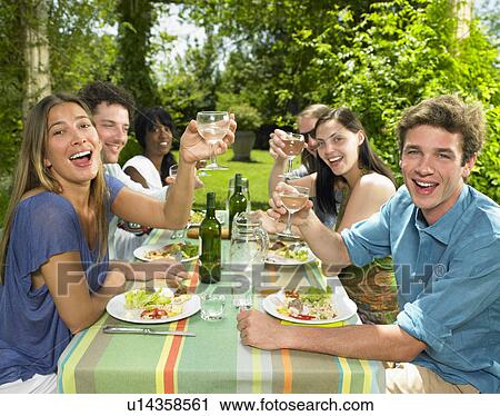 Stock Image - Friends having lunch in the garden. Fotosearch