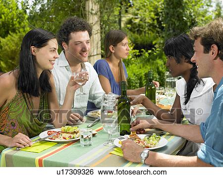 Friends having lunch in the garden View Large Photo Image Stock Photograph - Friends having lunch in the garden. Fotosearch