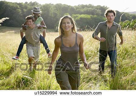 Friends running in a field View Large Photo Image Picture - Friends running in a field. Fotosearch