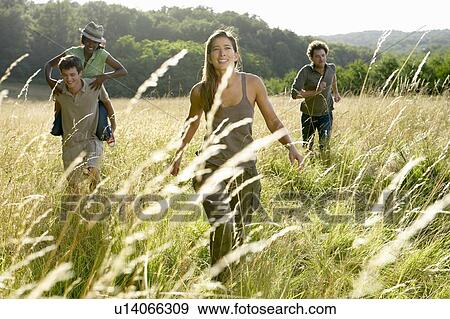Friends running in a field View Large Photo Image Stock Photo - Friends running in a field. Fotosearch