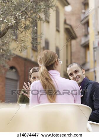 Stock Photo - Friends sitting at a cafe in a piazza. Fotosearch