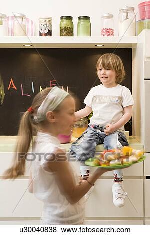 Stock Photo - Girl and boy cooking vegetables. Fotosearch