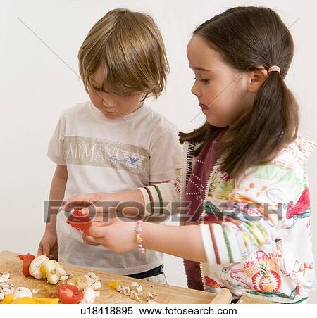 Stock Photography - Girl and boy cooking vegetables. Fotosearch