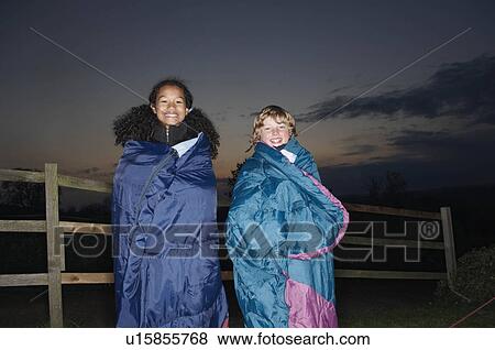Girl and boy in sleeping bags at dusk View Large Photo Image Stock Photo - Girl and boy in sleeping bags at dusk. Fotosearch