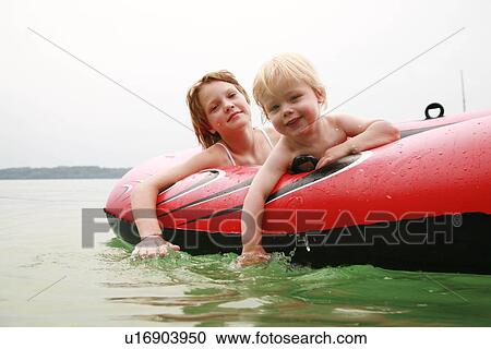 Girl and boy swimming with rubber boat View Large Photo Image Stock Image - Girl and boy swimming with rubber boat. Fotosearch