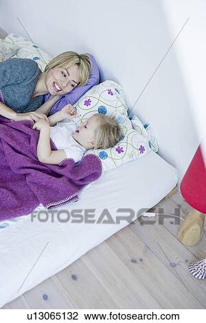 Girl and woman lying in bed tickling View Large Photo Image Stock Image - Girl and woman lying in bed tickling. Fotosearch